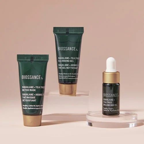 Biossance skincare products including a detox mask, cleansing gel, and balancing oil on a pastel background