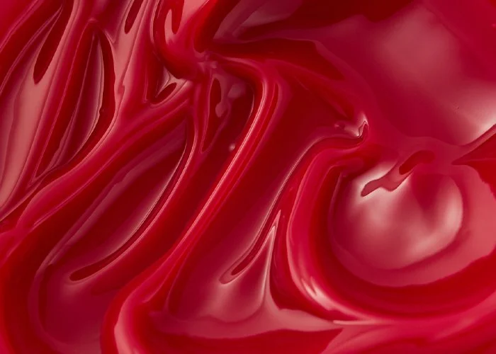 Close-up of swirling red and pink liquid or paint.