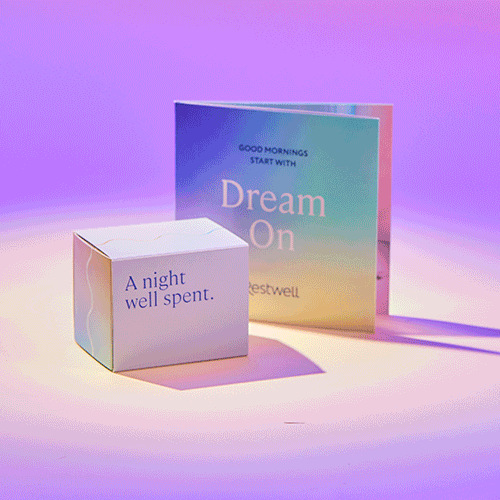 A pastel-colored box and a booklet featuring motivational quotes about dreams and mornings in front of a purple gradient background.