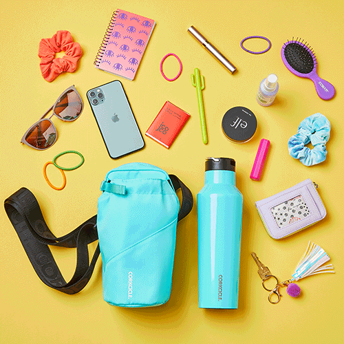 A collection of travel and personal accessories on a yellow background, including sunglasses, a blue water bottle, a backpack, a phone, a notebook, hair scrunchies, hairbrush, bath salts, lip balm, a wallet, a keychain, and rubber bands.