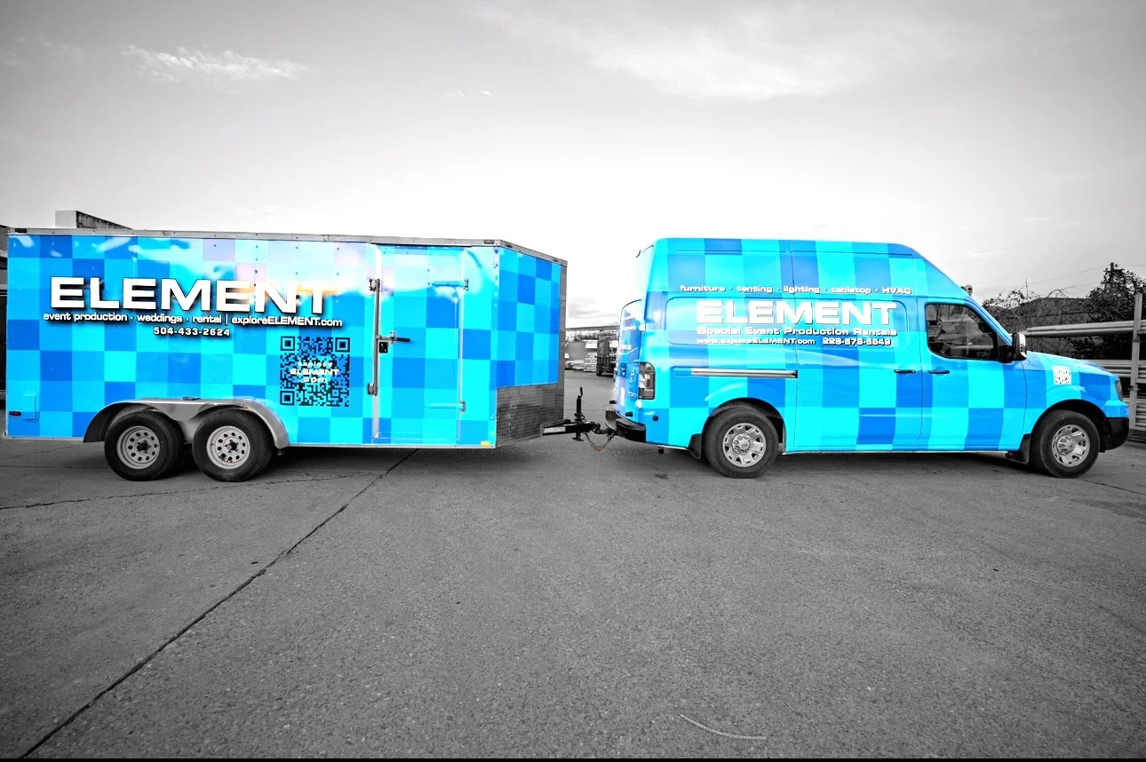 A blue checkered parked trailer and van with the company's branding, 'ELEMENT,' on a gray pavement with a cloudy sky overhead.