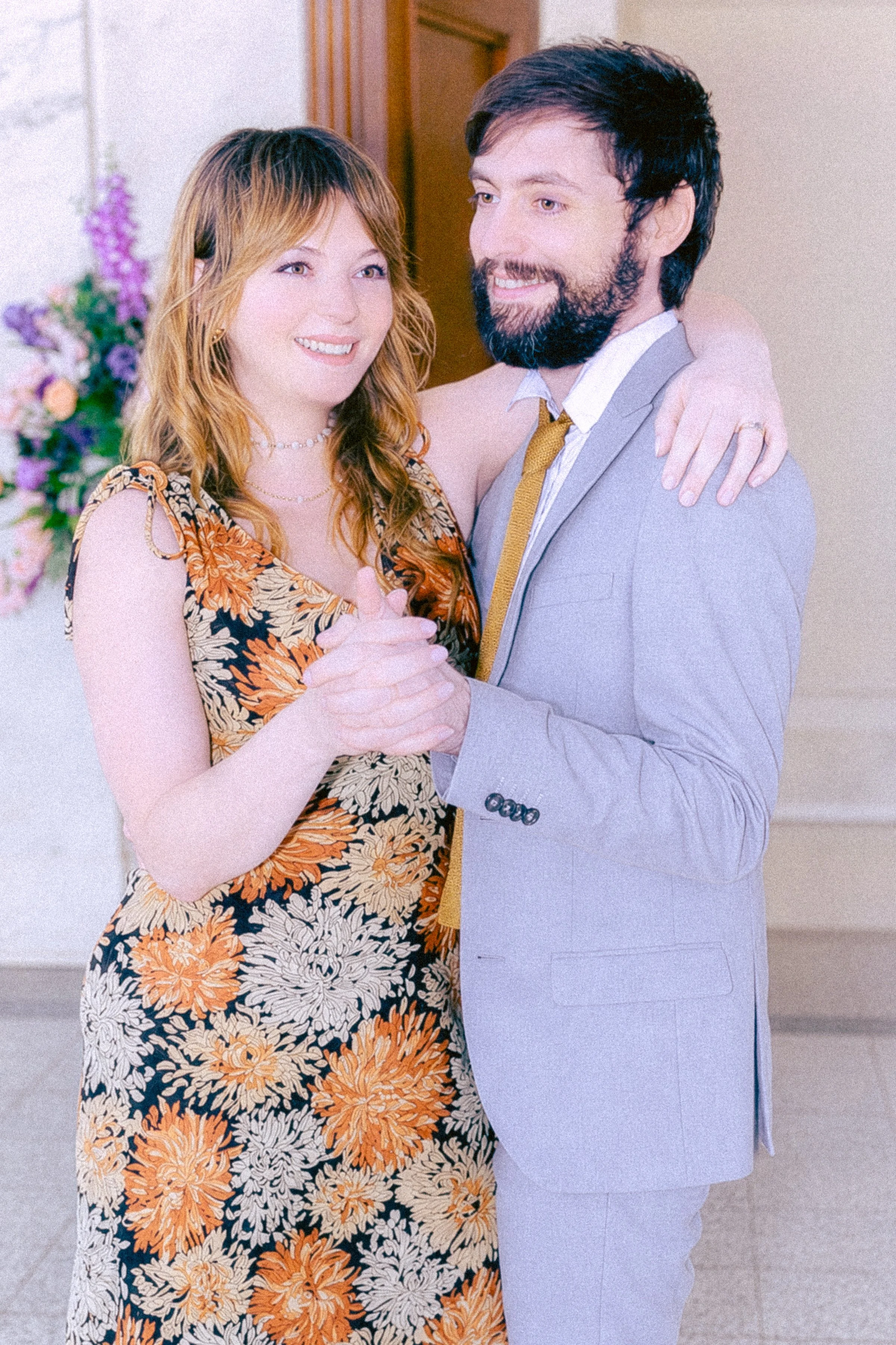 A man and woman dressed in wedding attire dancing or sharing a tender moment in a decorated indoor setting.