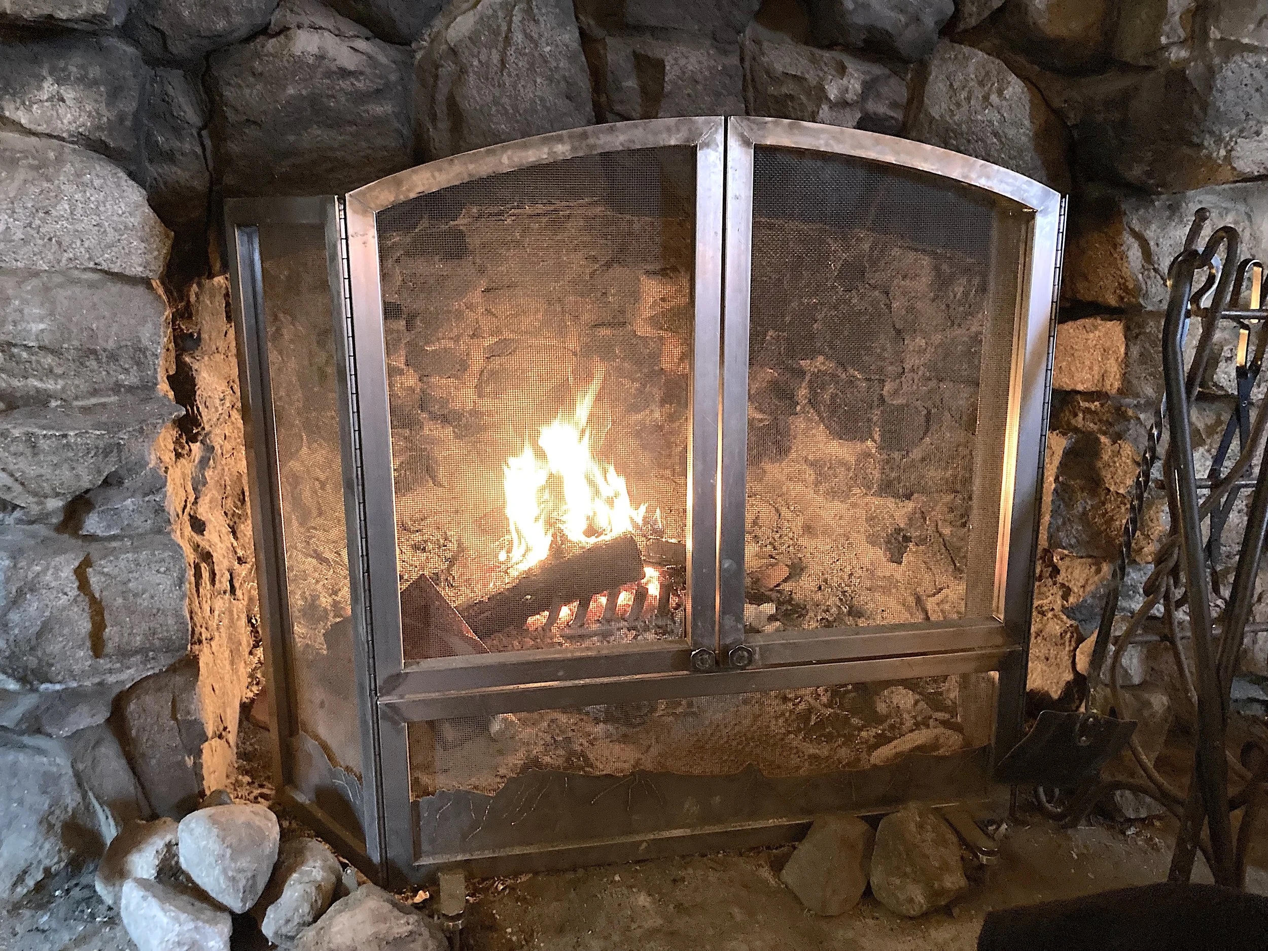 Fireplace screen, Tamarack Lodge, Mammoth Lakes, CA. Completed under the employment of Mammoth Mountain Ski Area. Scope: Design, fabrication, and installation of a fireplace screen that fit as if it were always part of the lodge, built in 1924. Doors