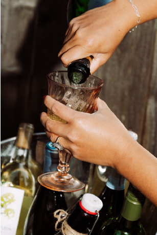 Person pouring champagne into a glass at a celebration table.