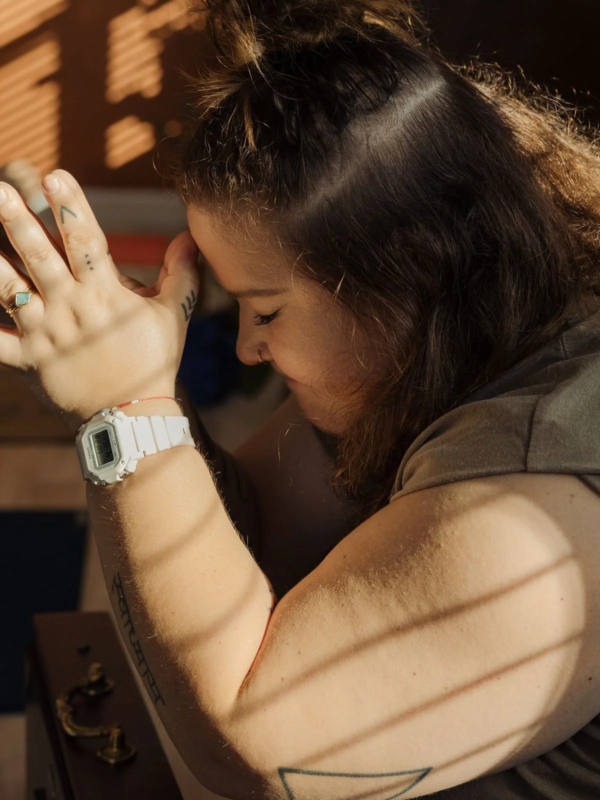 A woman with brunette hair, prayer hands.