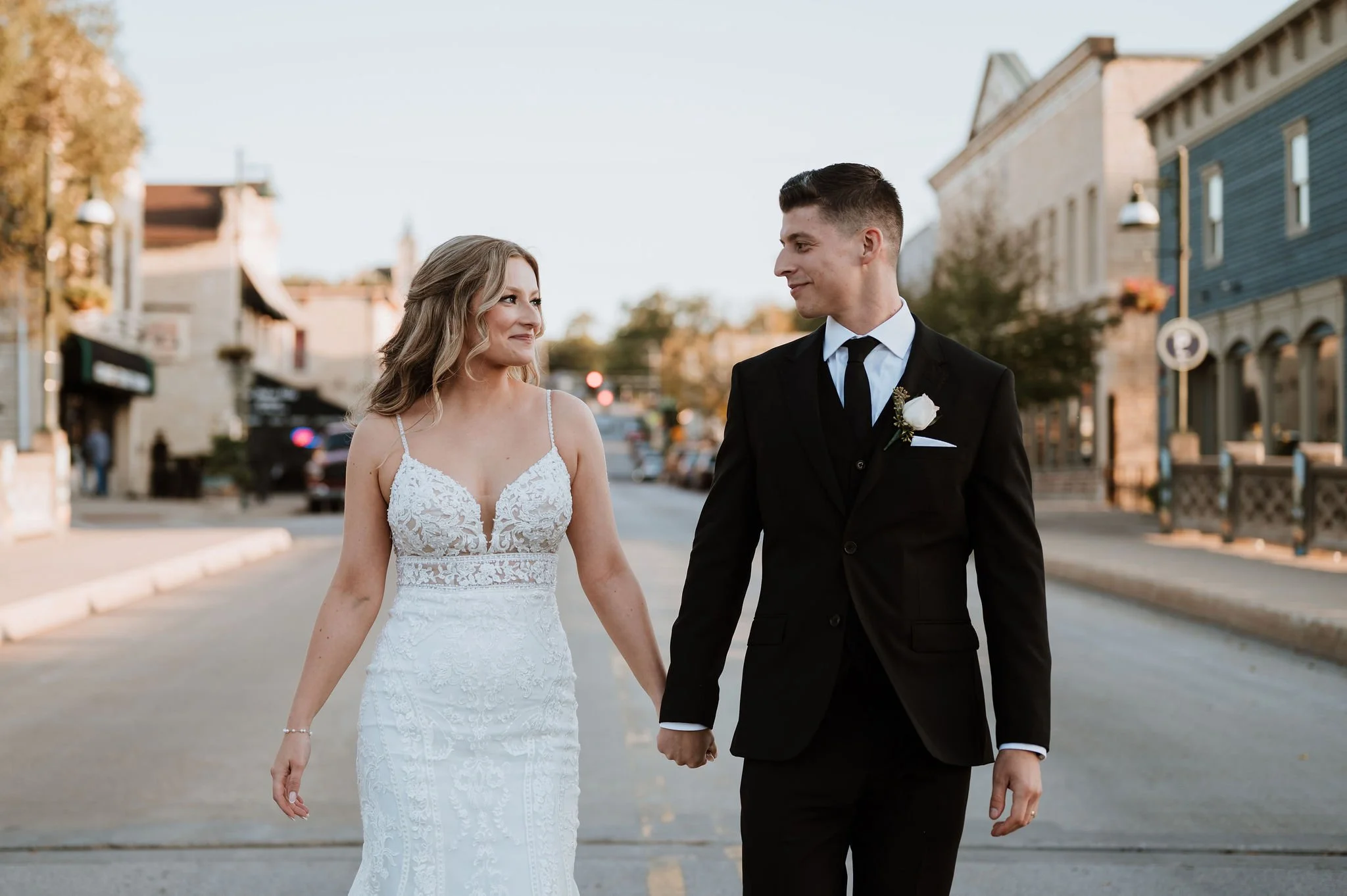 Bride and groom holding hands while walking in the street. Photo by Eight Hands Photography.