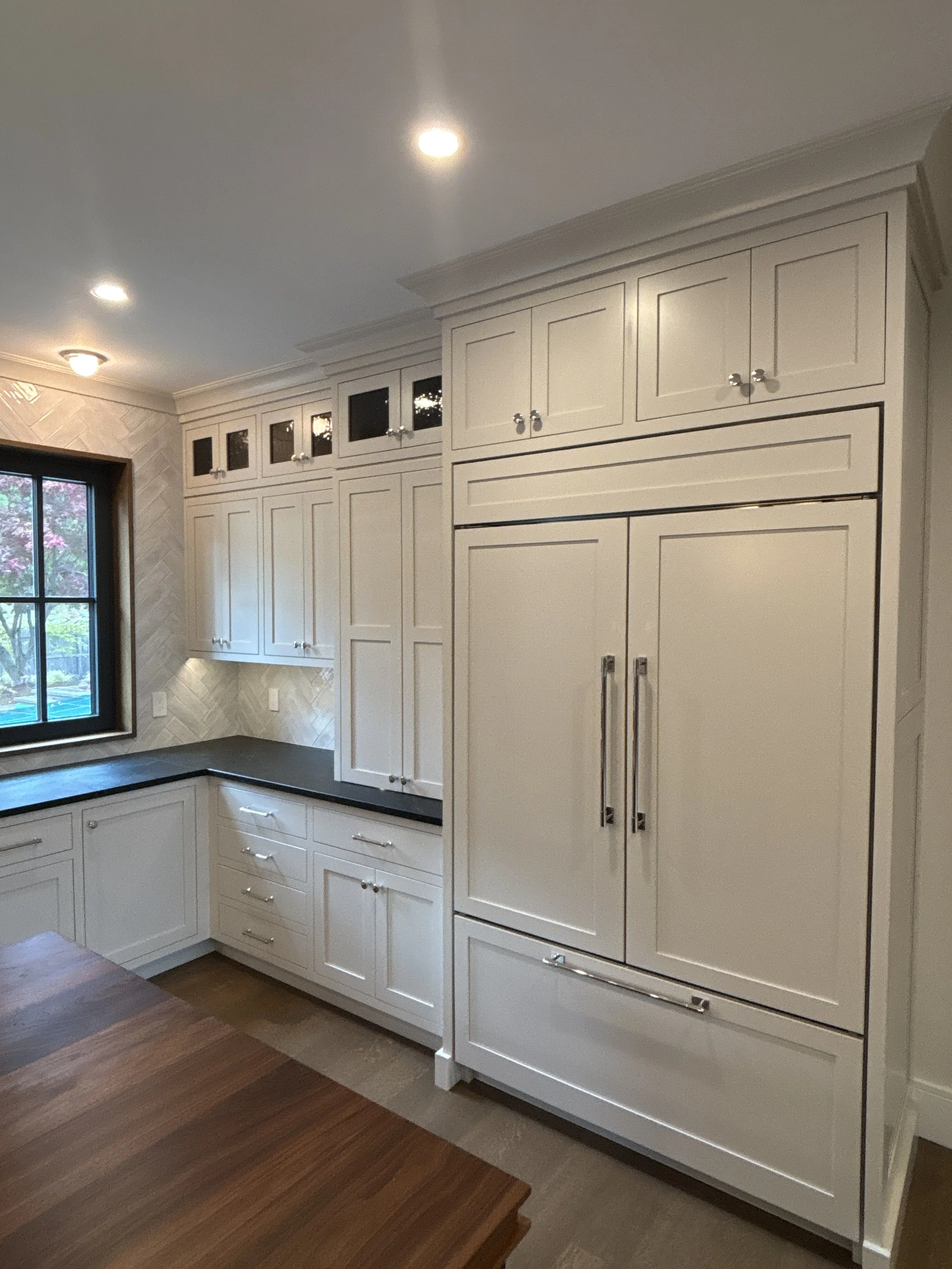 Best general contractor, home builder, and home remodeler on the Northshore in Andover, Massachusetts (MA), developed this modern high spacious kitchen with white cabinets, a large central island, pendant lighting, and an energy efficient window.