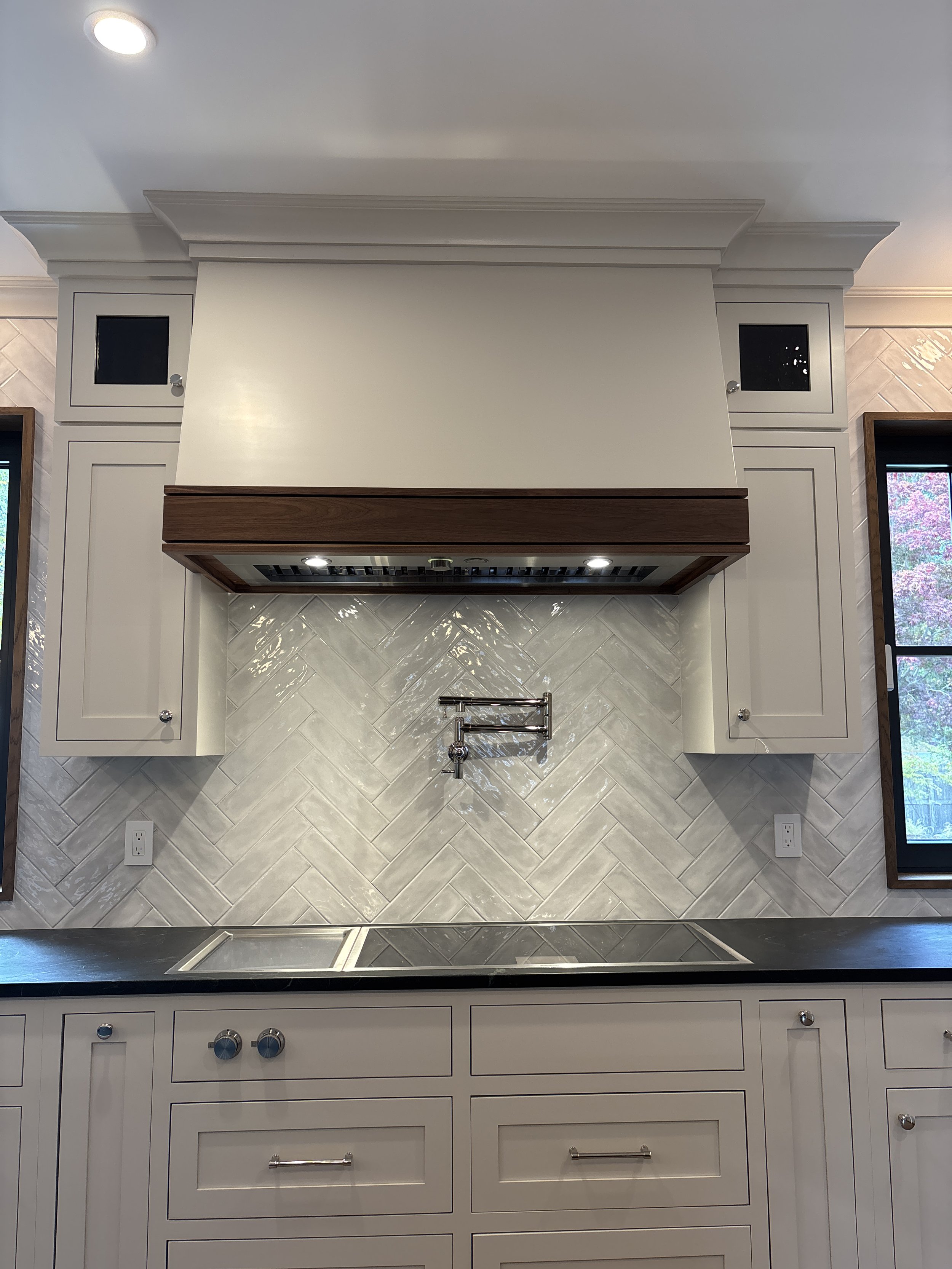 Best general contractor, home builder, and home remodeler on the Northshore in Andover, Massachusetts (MA), developed this modern high spacious kitchen with white cabinets, a large central island, pendant lighting, and an energy efficient window.