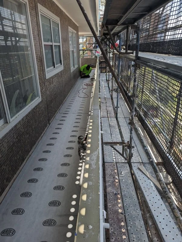 View of ardex waterproofing membrane being installed on exterior walkways