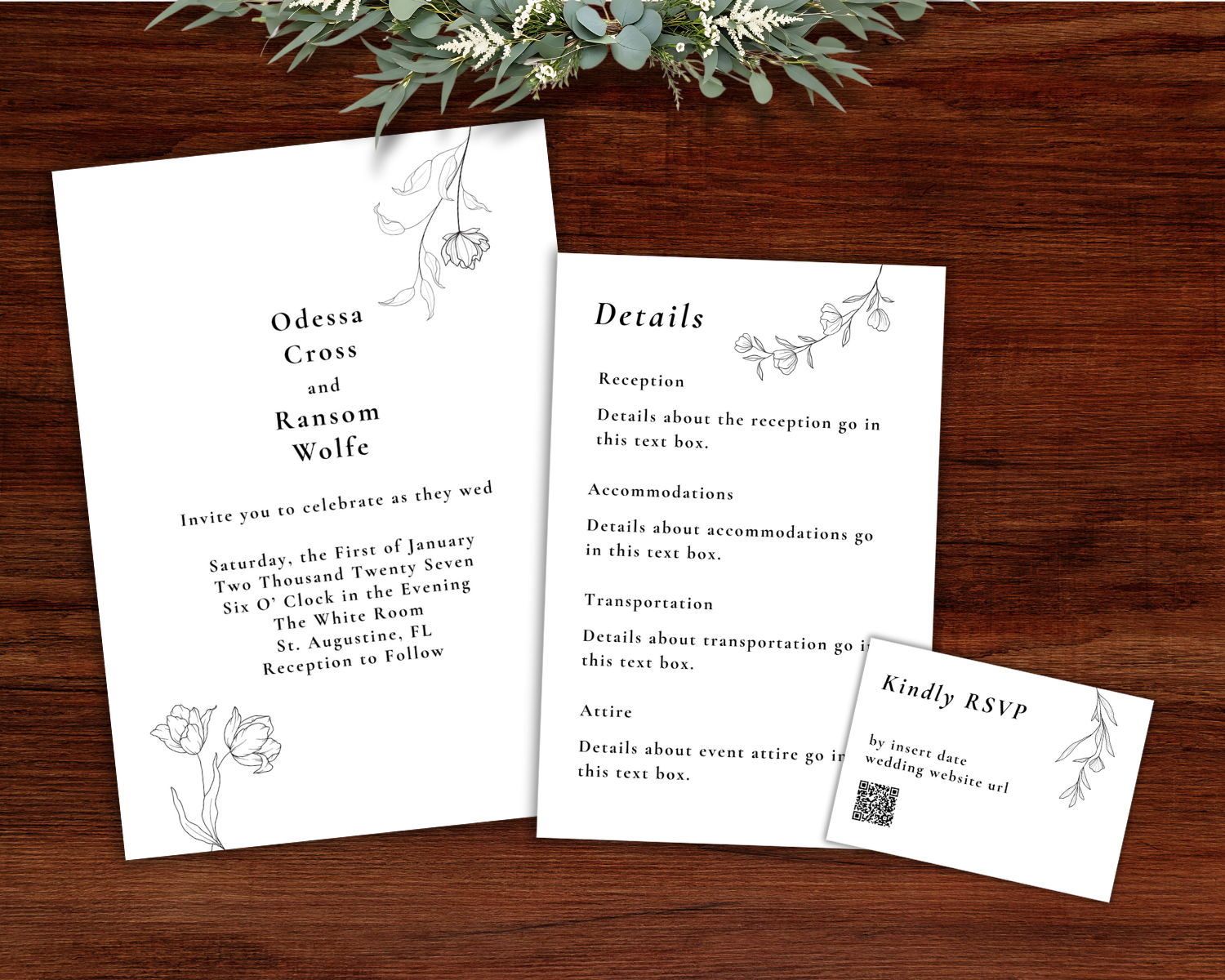 Wedding invitation set including a main invitation, details card, and RSVP card with floral design, on wooden surface with greenery above.