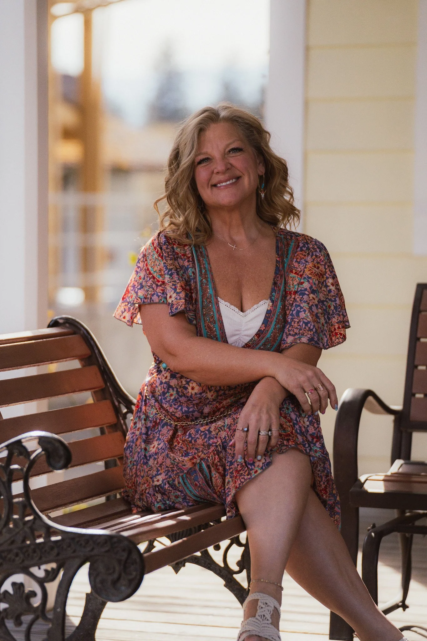 Lisa a blonde woman in a flowery dress sitting on a bench