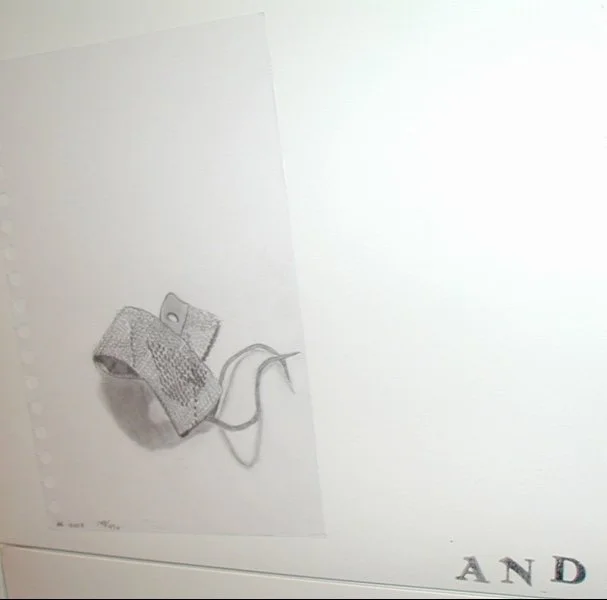 A crumpled textured fabric or paper object with a string attached, lying on a blank surface with printed text.