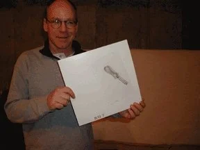 Person holding a white box with a graphic of a key on it.