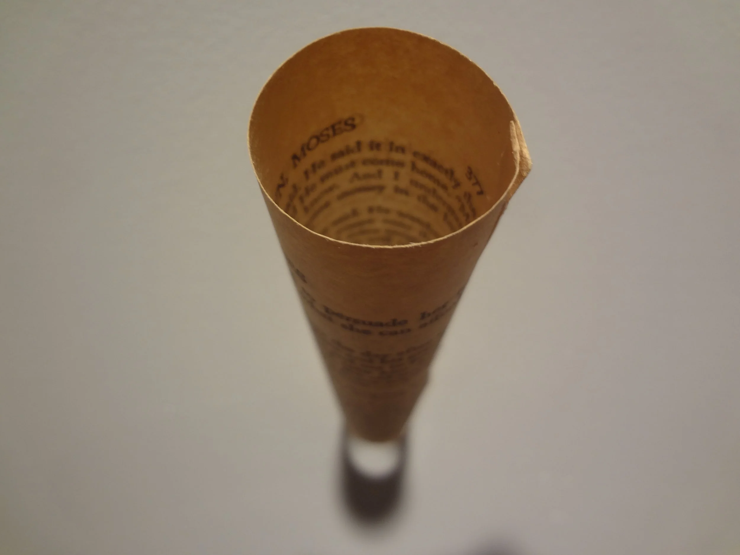 Close-up view of a rolled-up paper with text printed on the inside, viewed from above.
