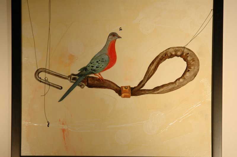 A mural of a bird sitting on a twisted branch, with wires attached, and a metal clamp.