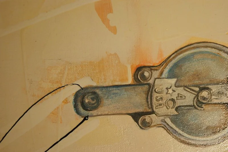 Close-up of a mechanical part with screws, markings, and an electric wire attached.