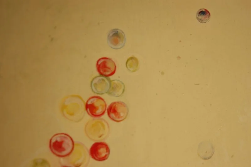 Red and yellow bubbles floating against a yellow wall.