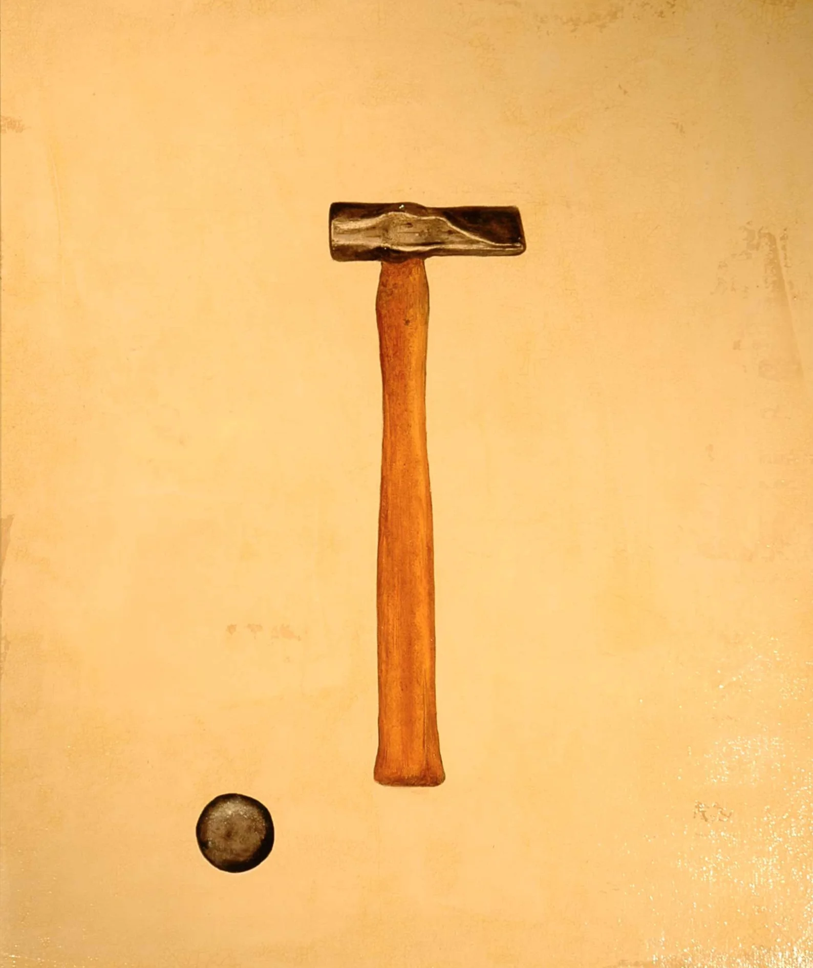 A hammer with a wooden handle and a metal head is positioned vertically, with a small round object below it against a yellow background.