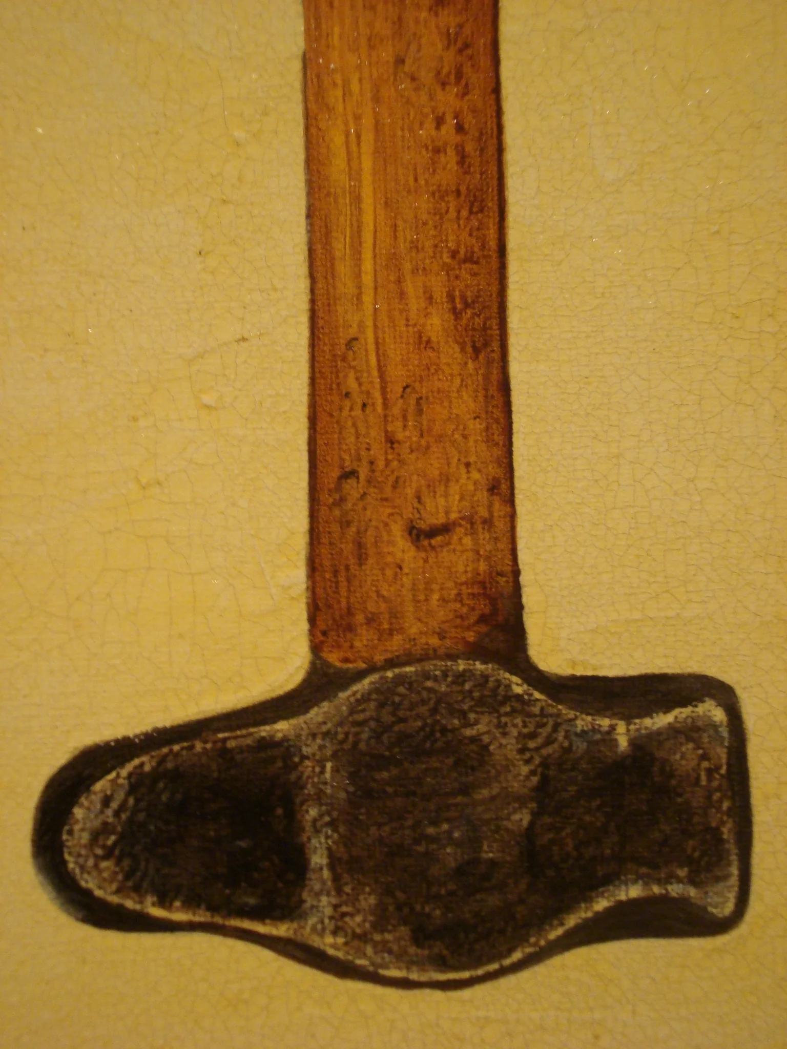 Close-up of a wooden and plastic object on a beige, cracked surface.