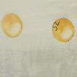 Two golf balls on a light-colored surface, one plain and the other with a logo, positioned close together.