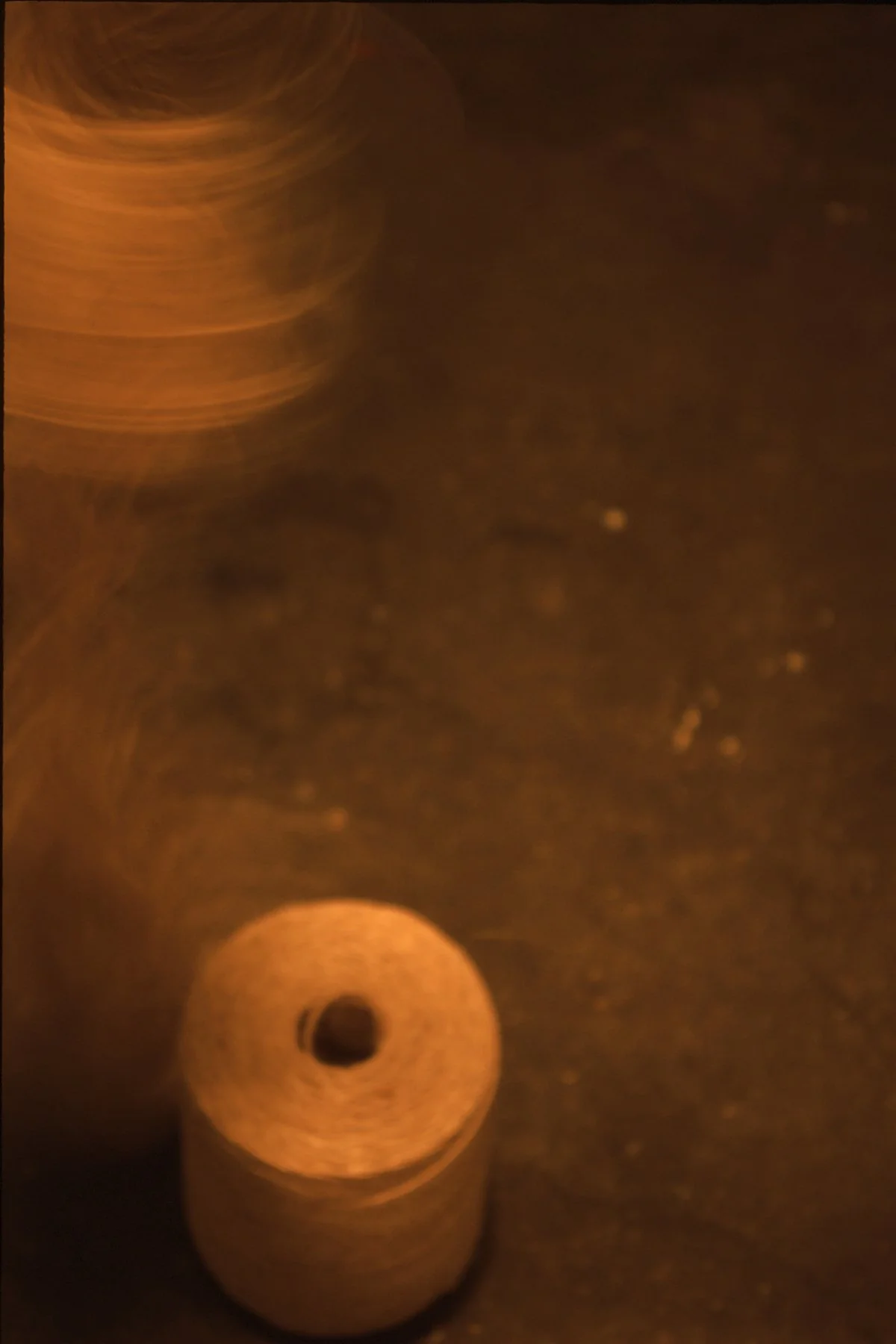 A close-up photo of a brown cork stopper against a dark background, with motion blur showing a circular pattern.