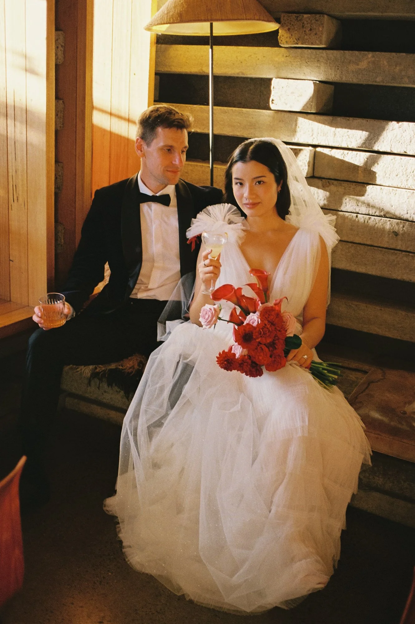 Bride and groom relaxing with cocktails at Monster Kitchen & Bar, Ovolo Canberra wedding venue, captured on 35mm film by Corinna & Dylan, canberra film photography