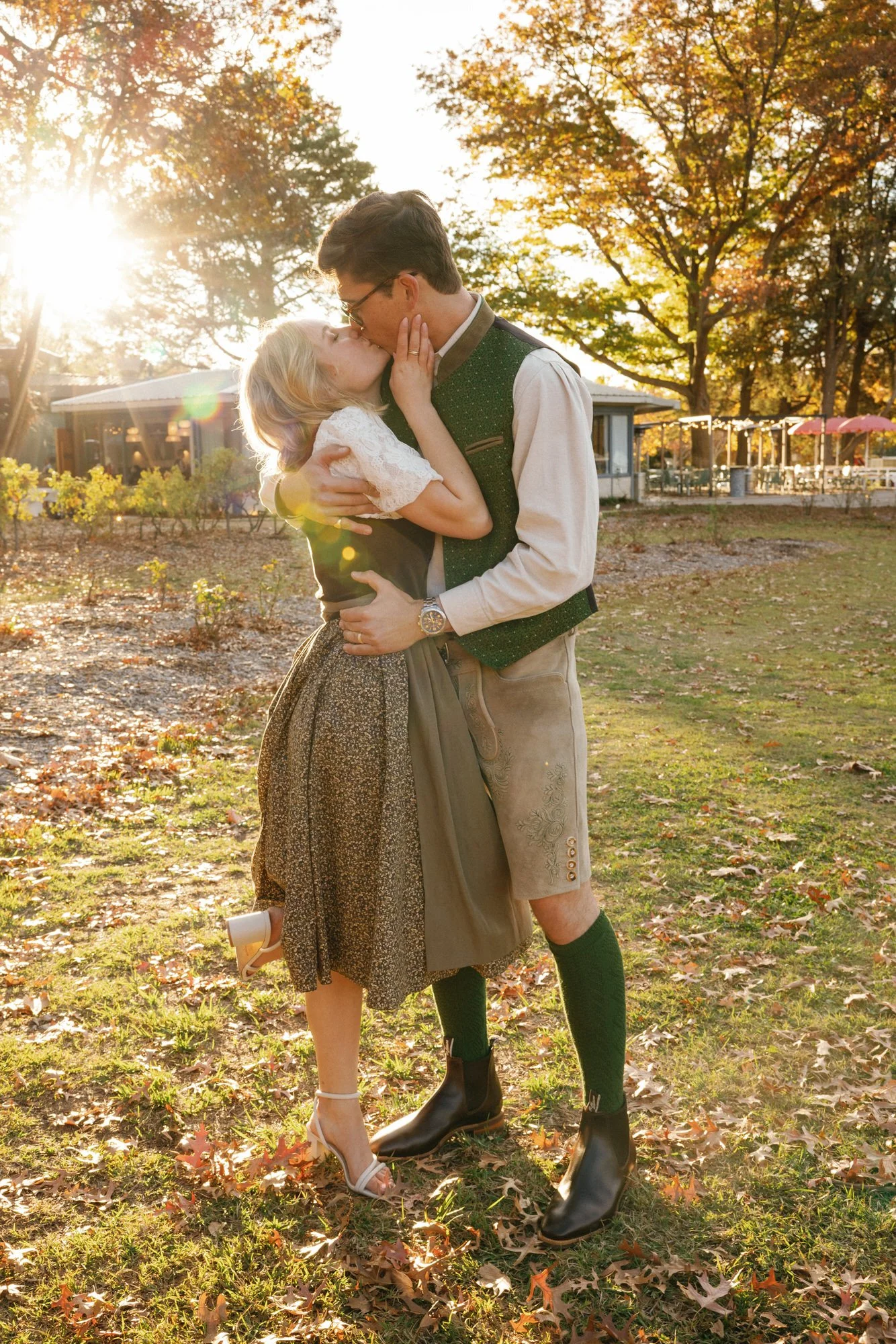 Romantic wedding photo of a bride and groom kissing in golden autumn light, wearing traditional attire, captured at Ballyhoo, Canberra