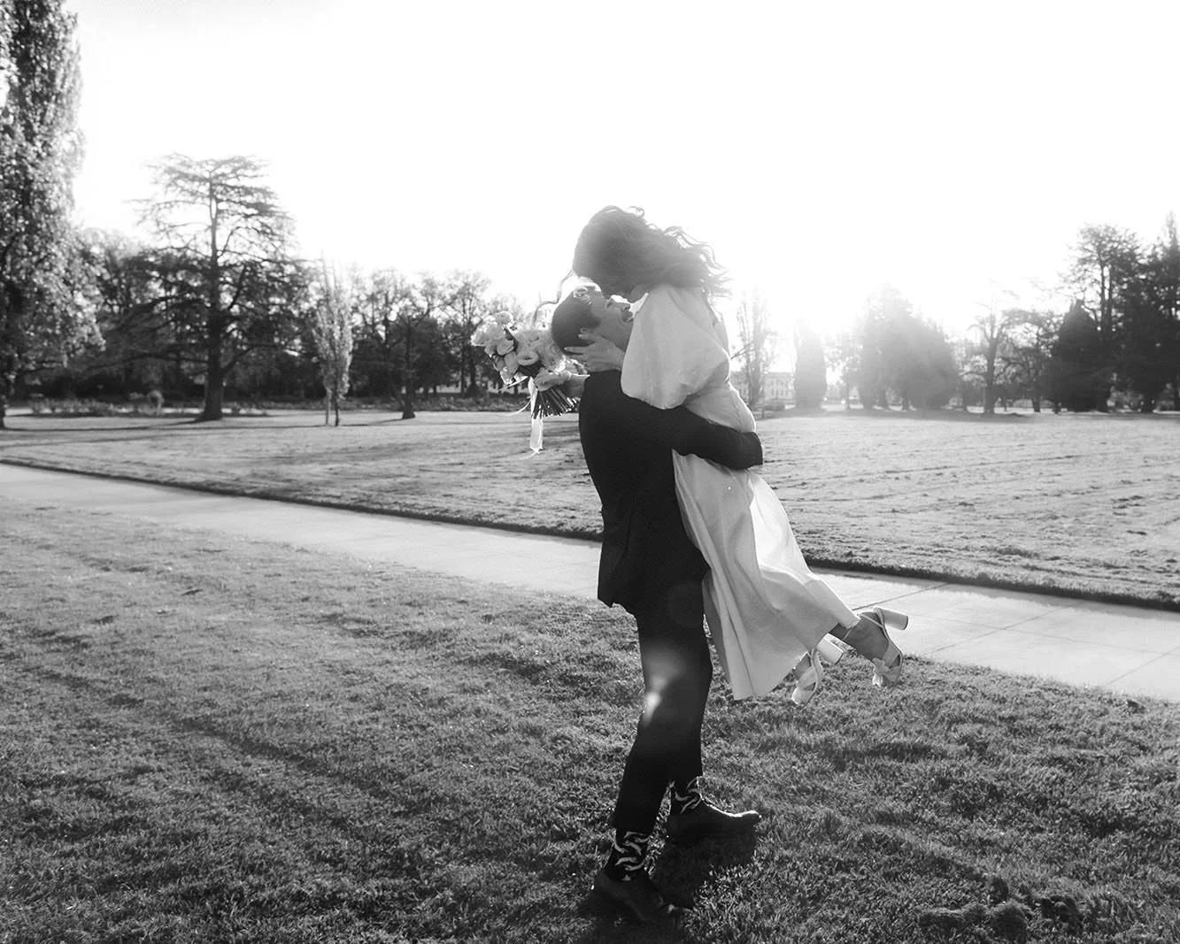 Canberra elopement photography — groom lifting the bride into the air at golden hour in the parliamentary triangle.