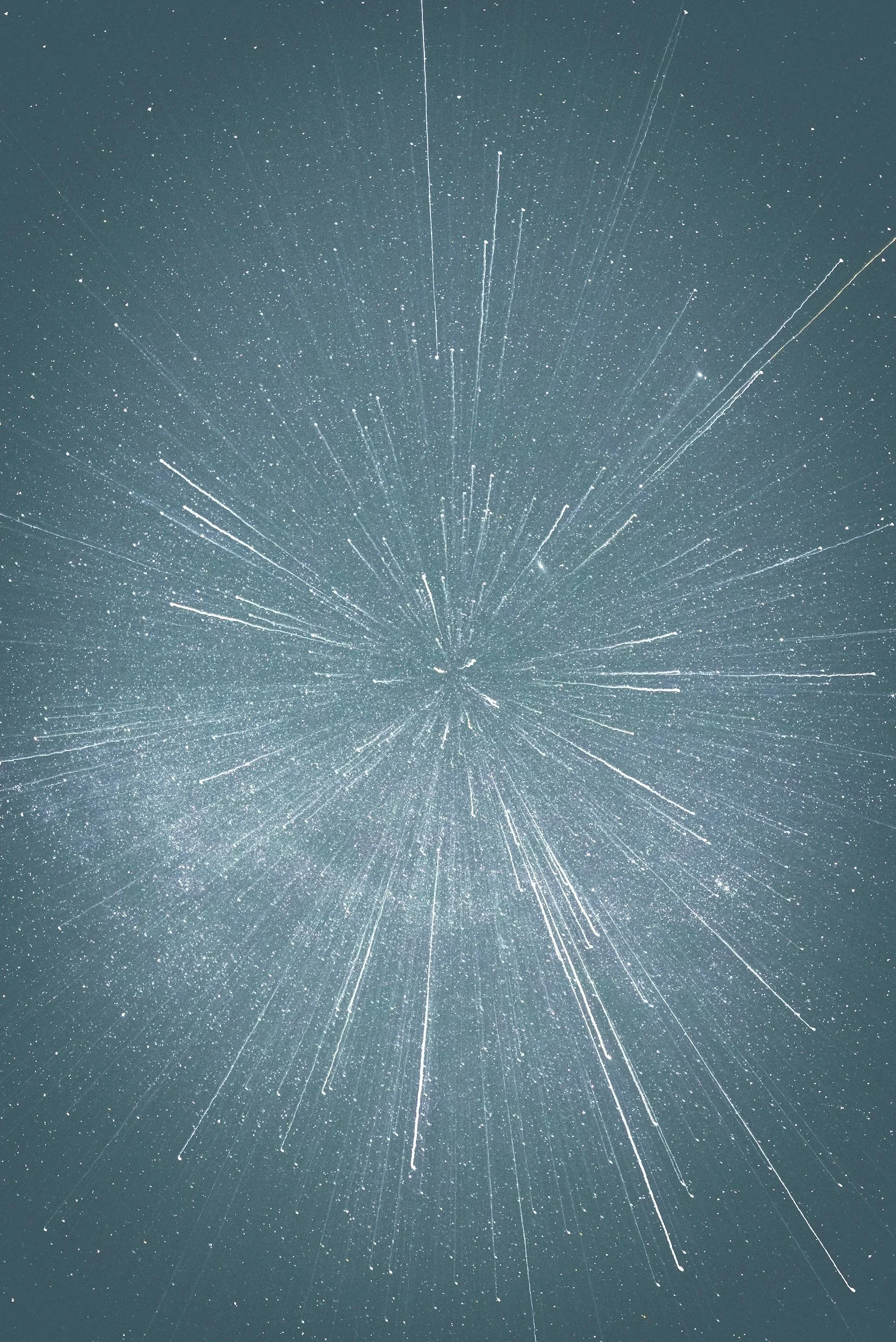 Long exposure photograph of star trails radiating outward in a circular pattern in the night sky.