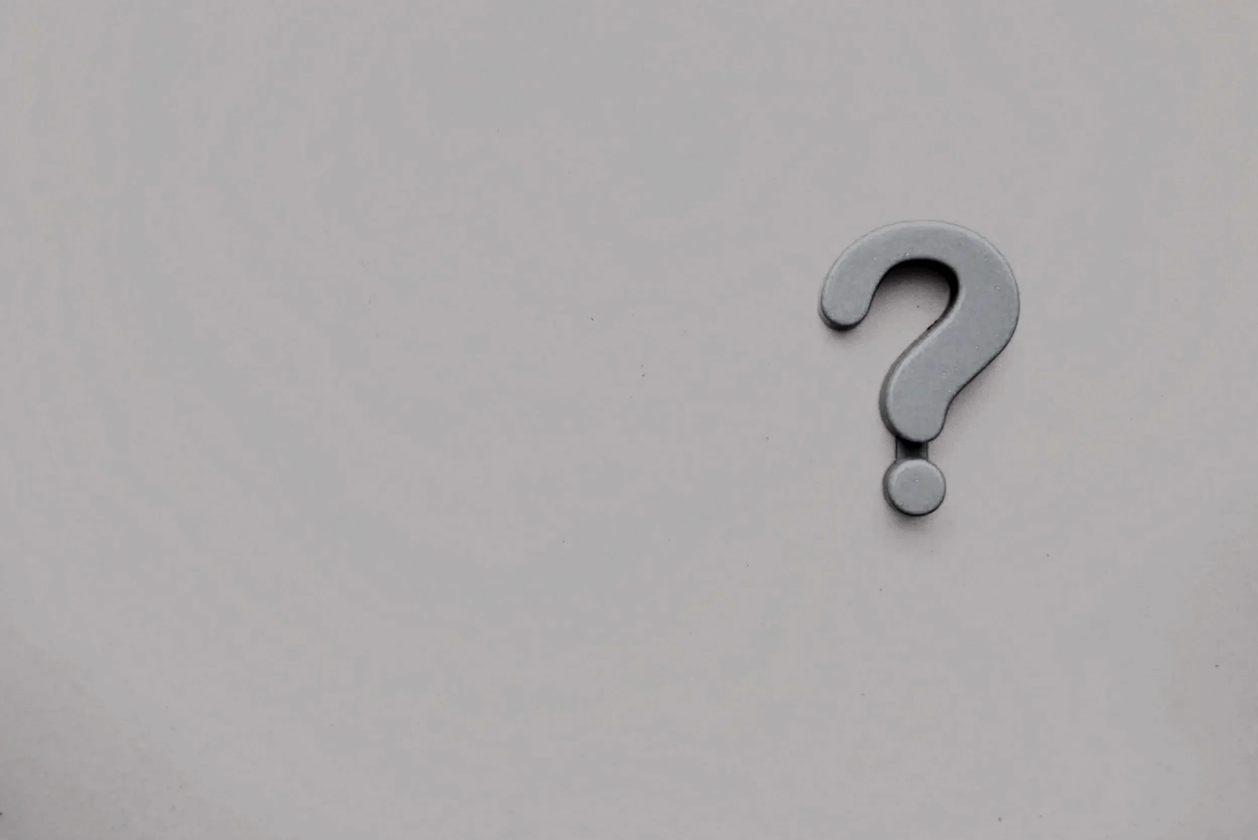 Gray question mark on a plain light gray background.