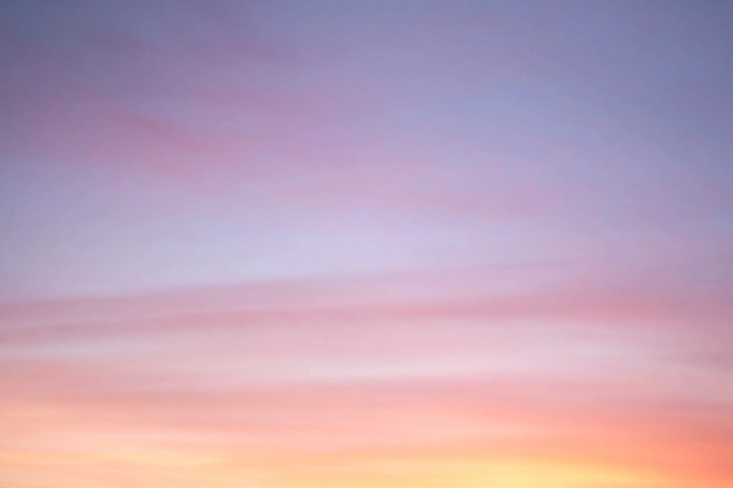 A sky during sunset with a gradient of pink, purple, and yellow colors. Online therapy for perimenopause in California.