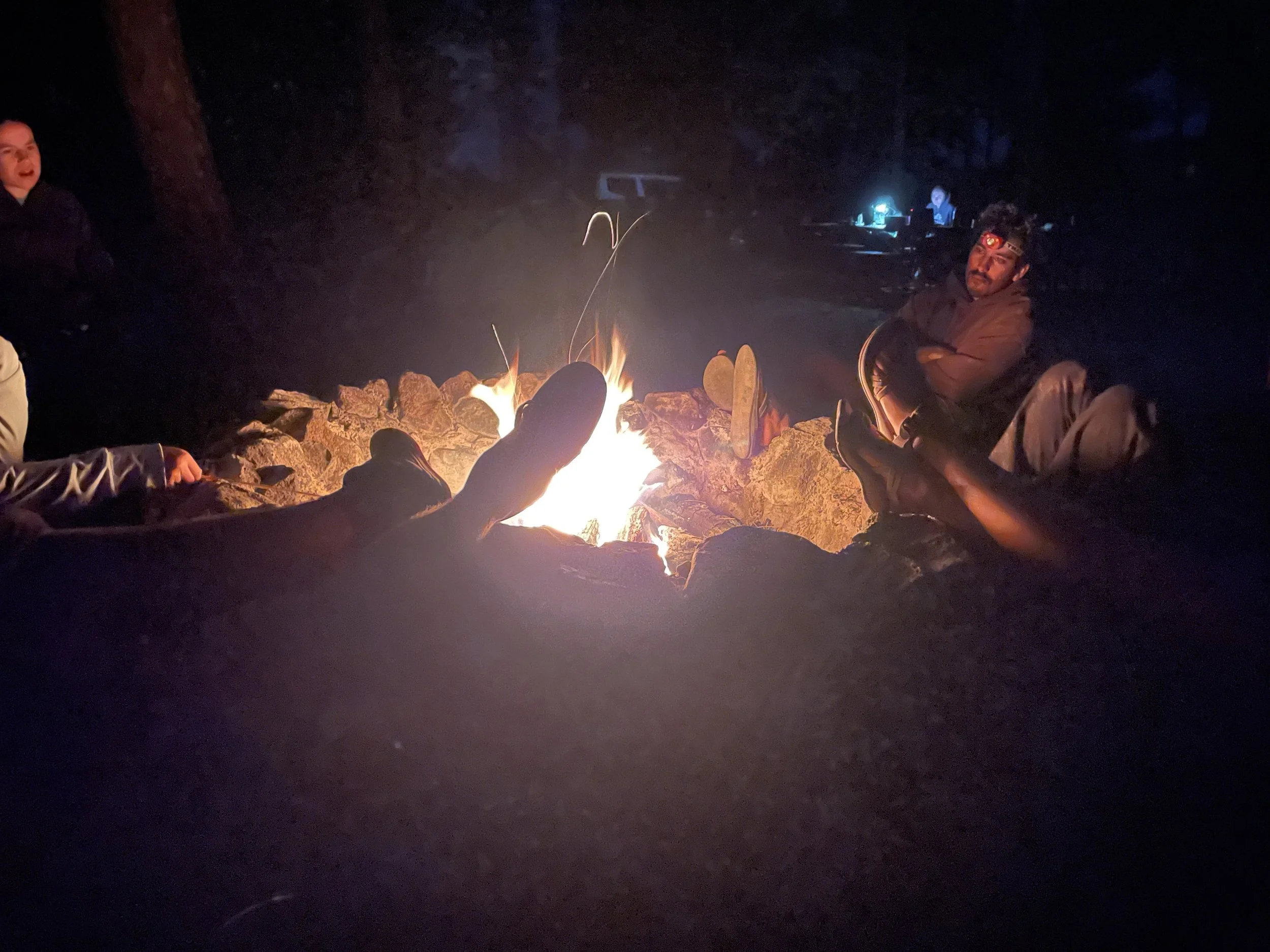 SAGE, Summer of Applied Geophysical Experience. People sitting around a campfire at night outdoors.