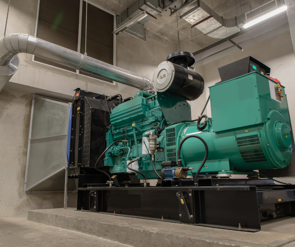 Industrial generator set in a concrete room with ventilation ducting and electrical equipment.
