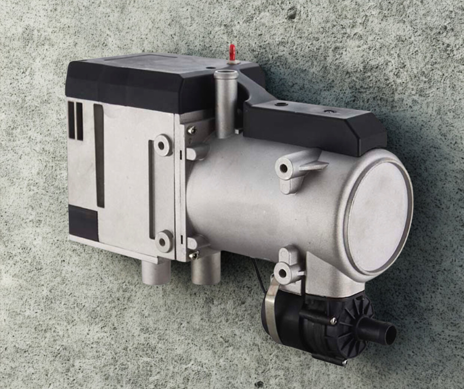 A small electric or mechanical motor with a black and silver body mounted on a green textured wall.