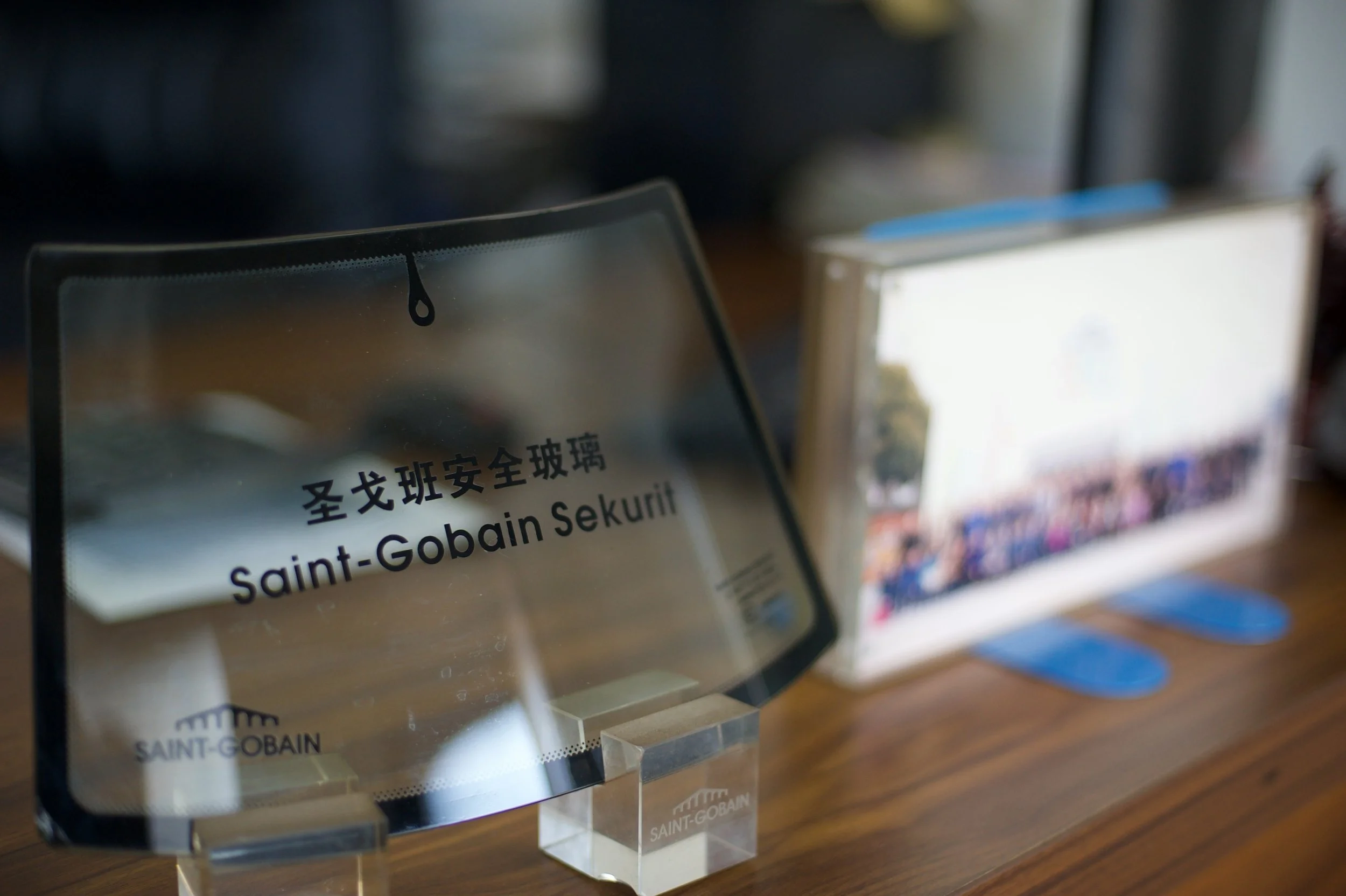 Close-up of a genuine Saint-Gobain Sekurit automotive windshield, showcasing its OE quality logo and curvature.
