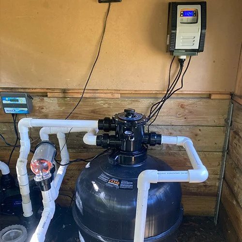 A pool filtration system setup with pipes and control panel.