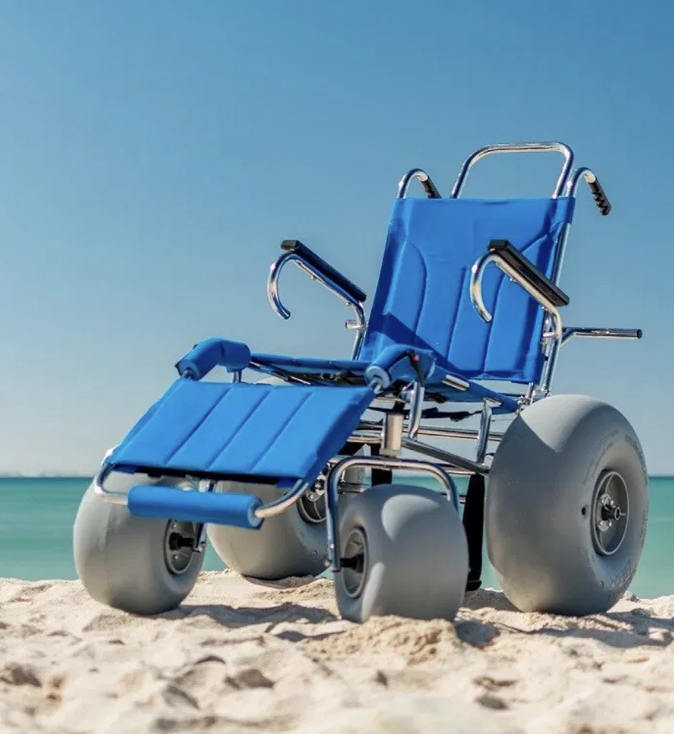 Wheelchair with large off-road wheels on a sandy beach.