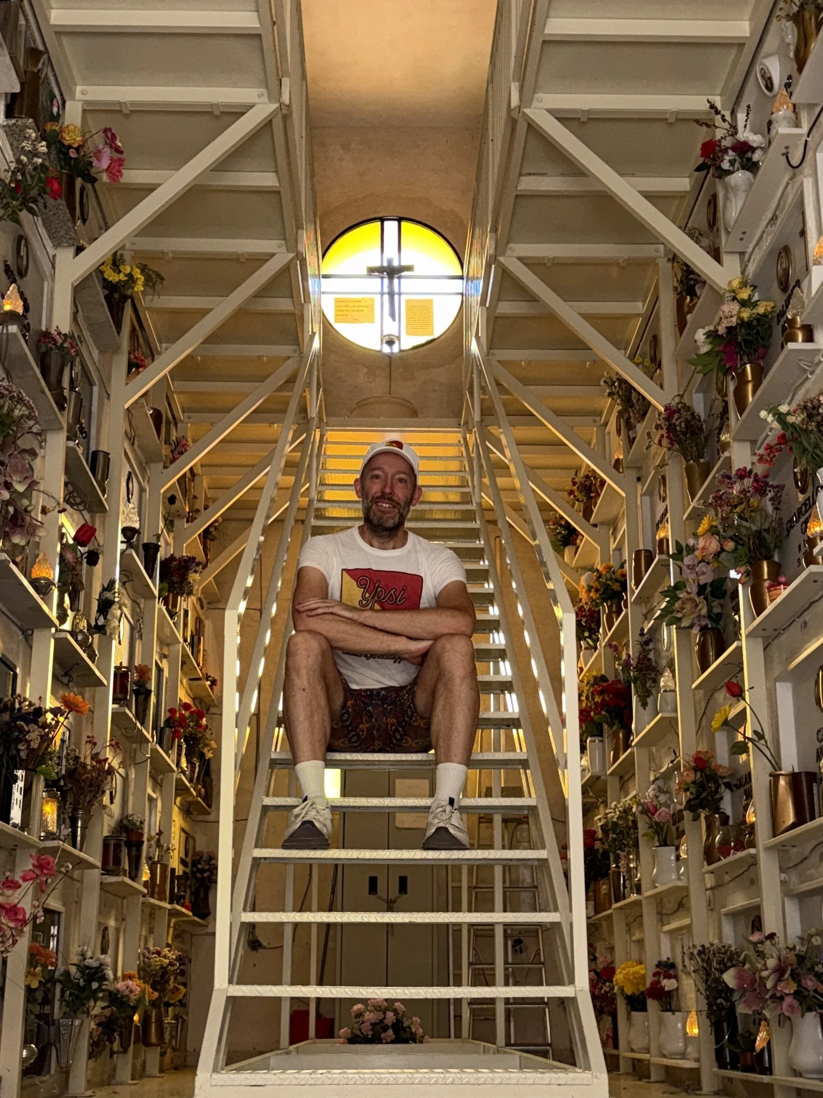 YpsoRoots Founder Daniel Tills sitting inside a congregation chapel in the cemetery of Castelbuono, Sicily