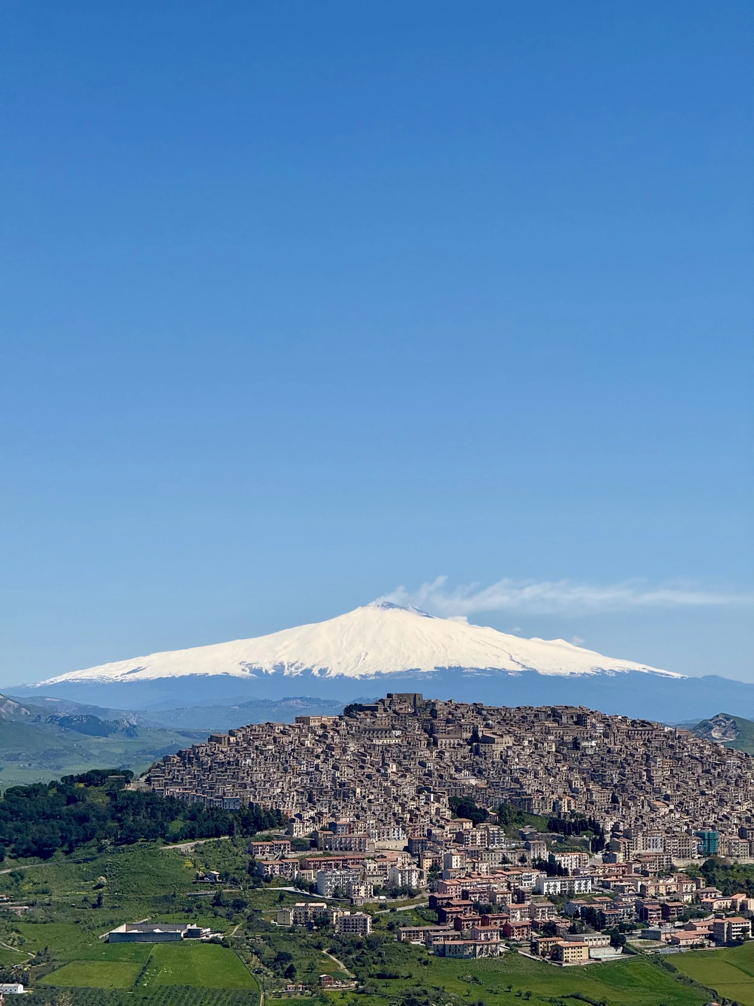 A view of Gangi in Sicily with a snow-capped Mount Etna providing a dramatic backdrop