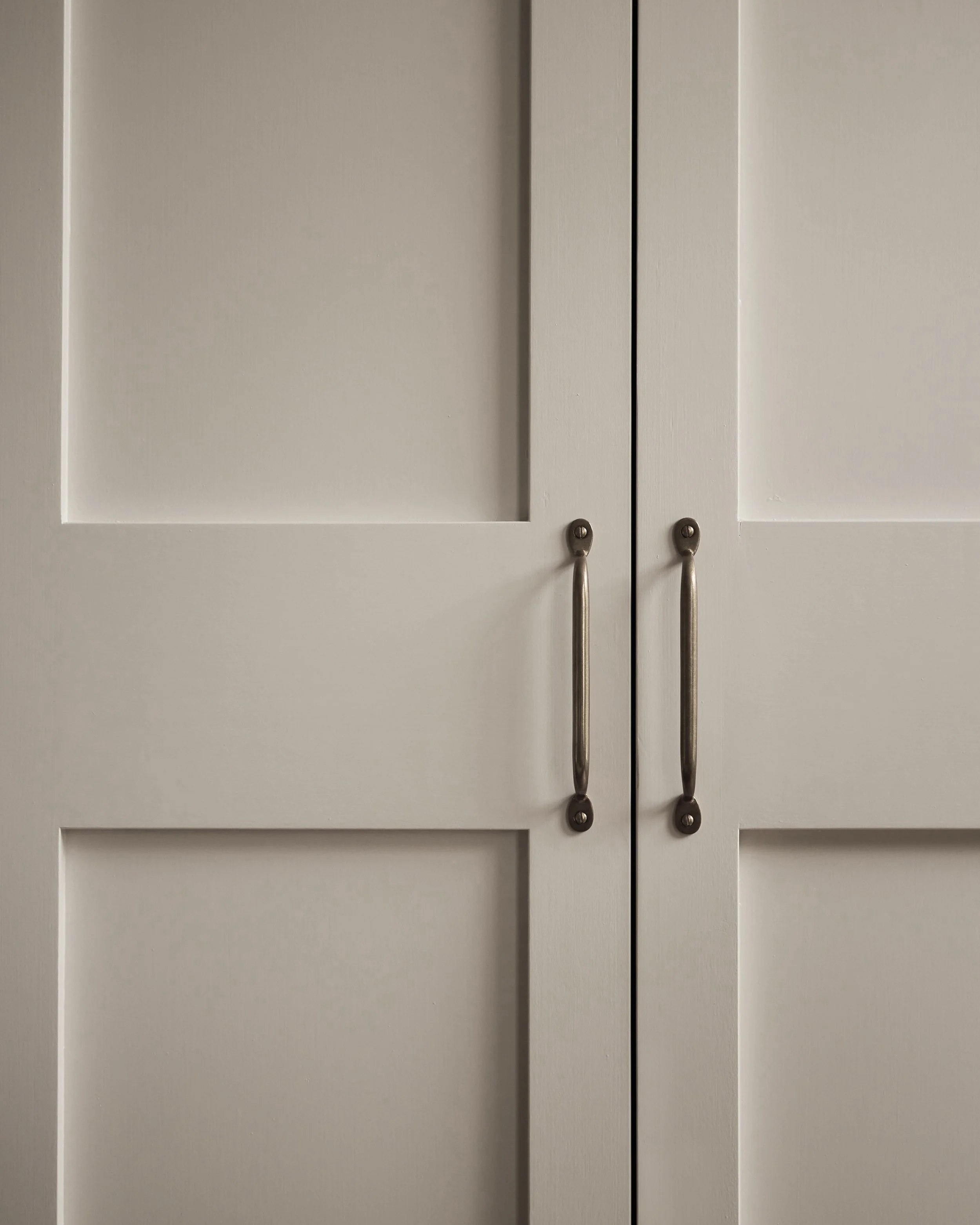 Close-up of cream-colored cabinet doors with silver handles