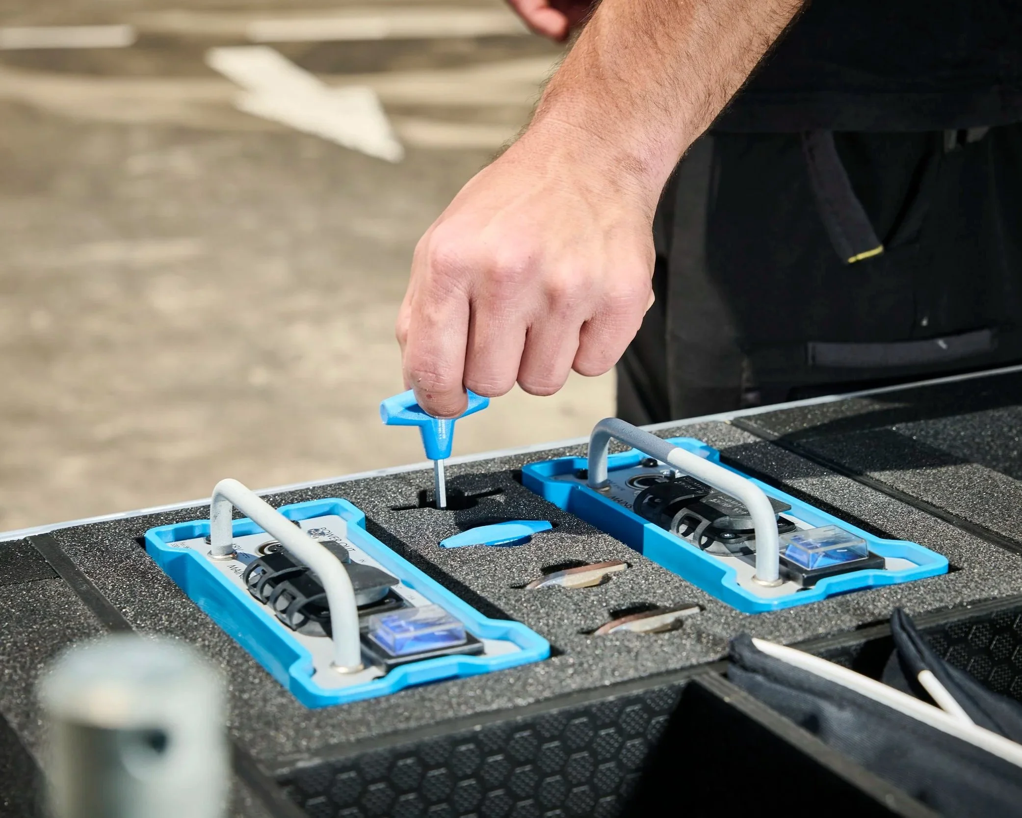 Close up of hex key being placed in a friction fit slot that was custom cut in a foam-lined case.
