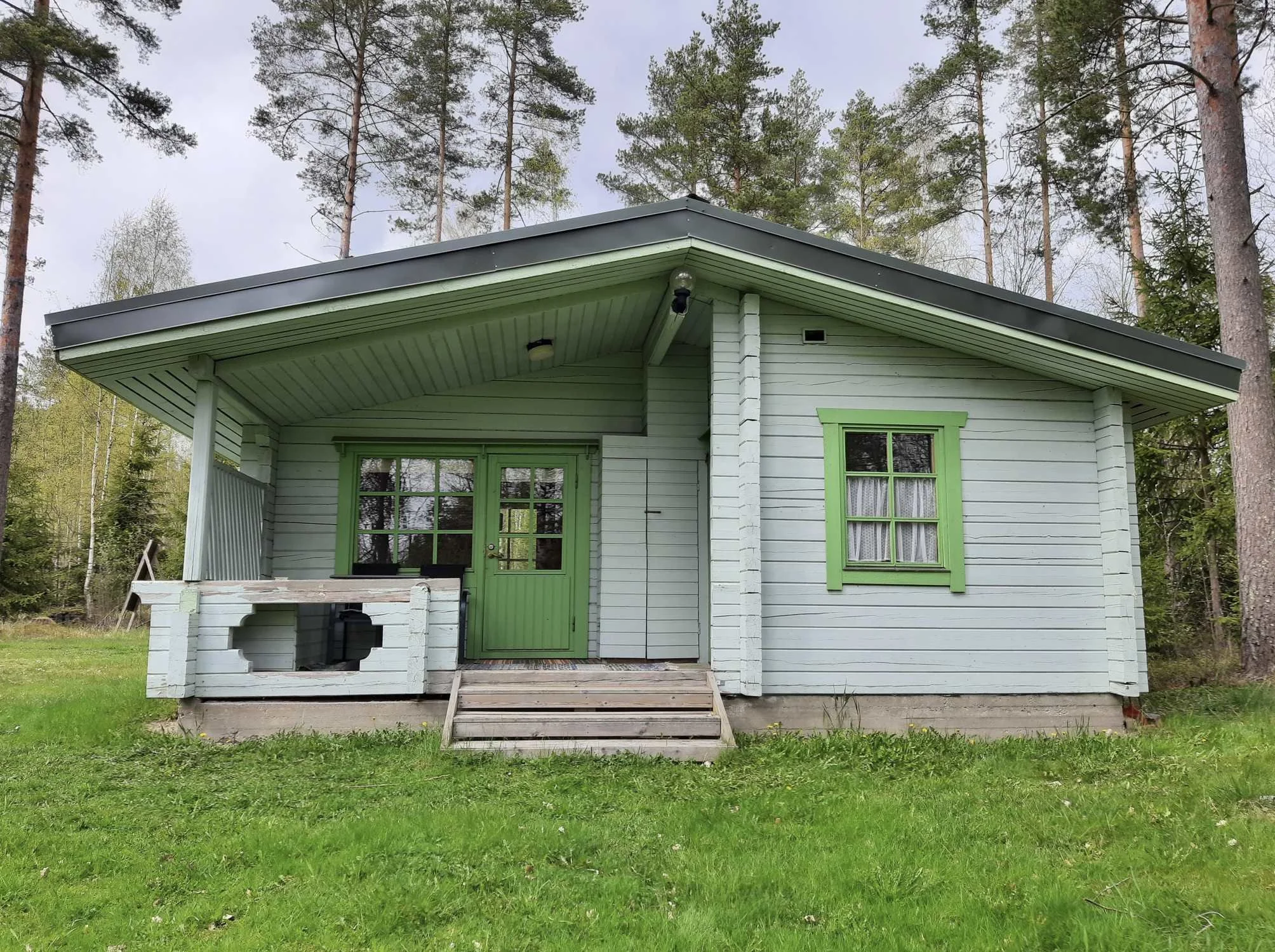 Vaaleansininen mökki idyllisessa maalailasmiljöössä