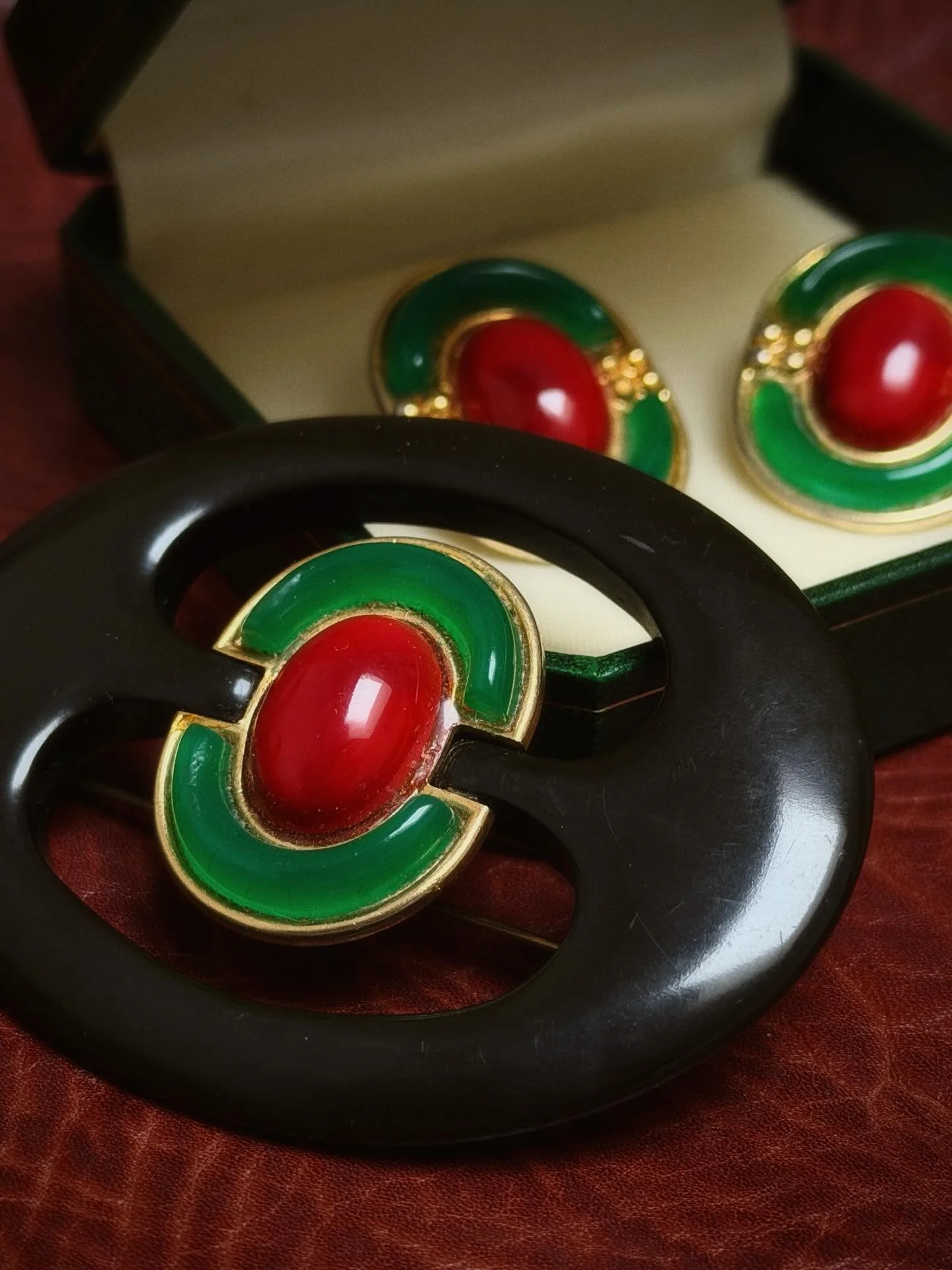 1970s Christian Dior brooch &amp; earrings set ❤️💚

Bold red cabochons framed in vibrant green enamel and gold-tone detailing, with a sculptural black-set brooch and matching clip earrings. The earrings were found in France and the brooch in Japan &