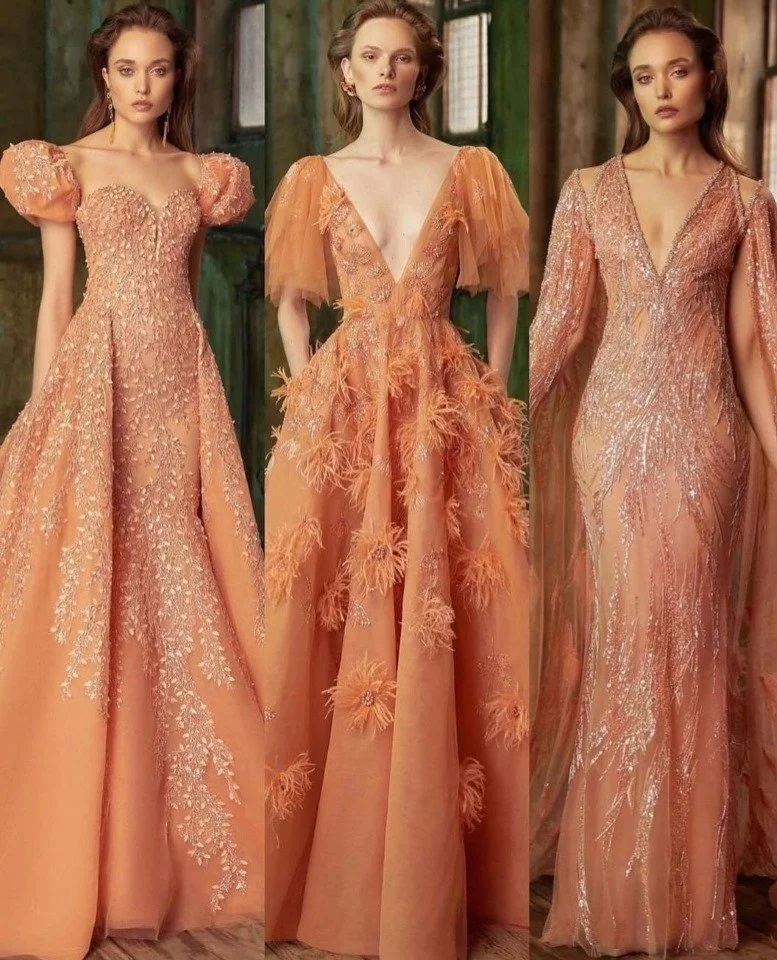 Tre vrouwen in elegante peachy stoffen jurken met veel details en texturen, staand in een rustieke, houten omgeving.