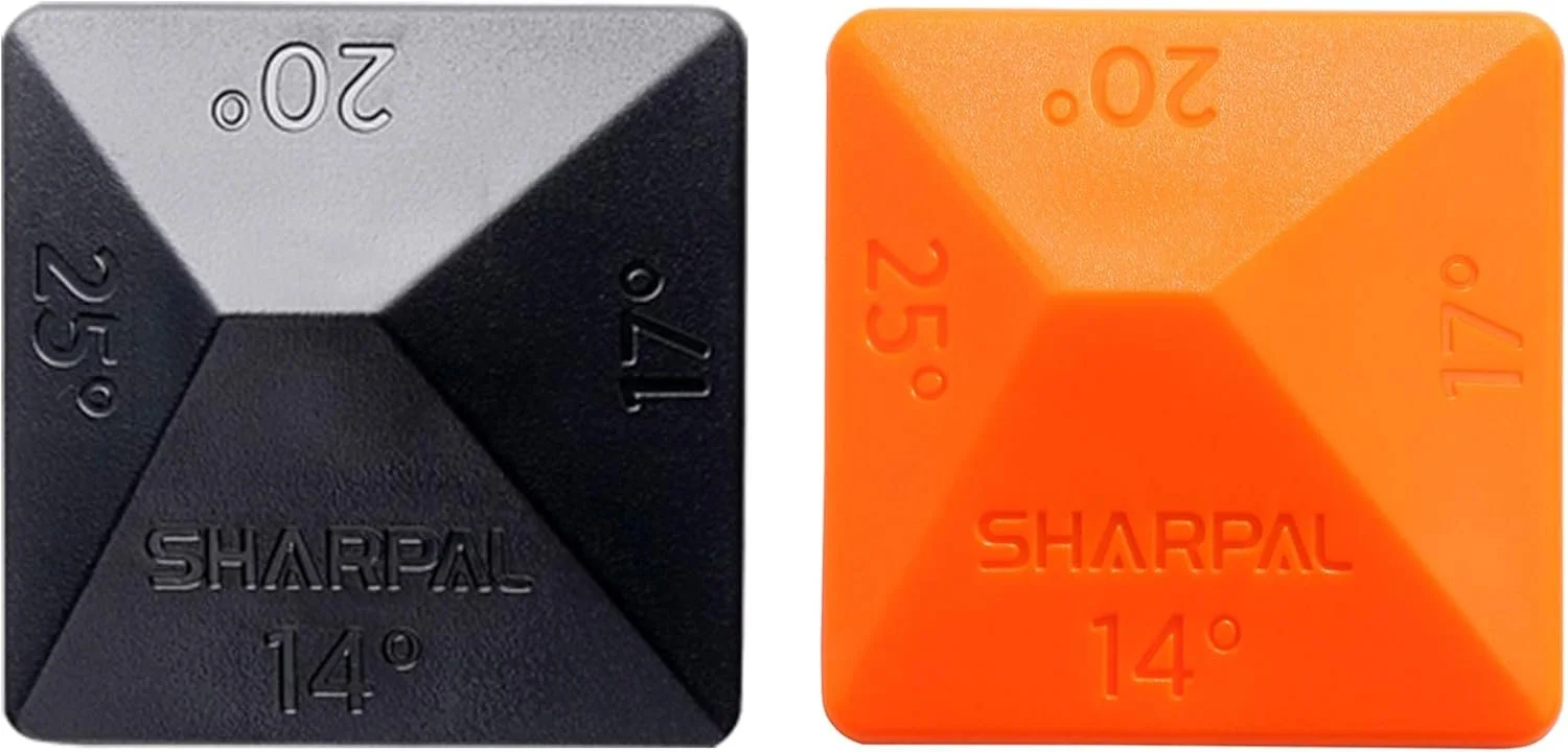 Two square-shaped knife sharpening stones, one black with silver accents labeled '20°', '15°, '14°', and '25°' with the brand name 'Sharpal' embossed, and one orange with embossed markings '20°', '17°', '25°', and '14°' and the brand name 'Sharpal'.