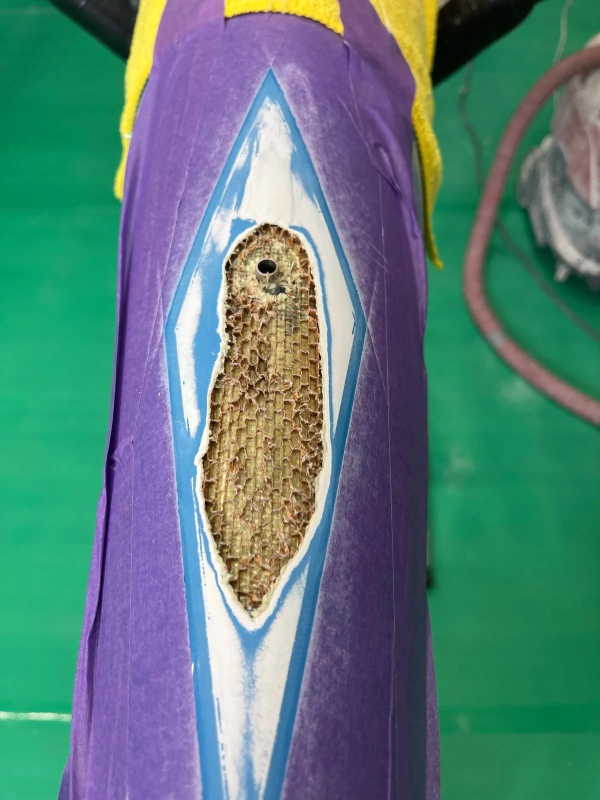 Close-up of a skateboard deck with a cut-out revealing the honeycomb structure inside.