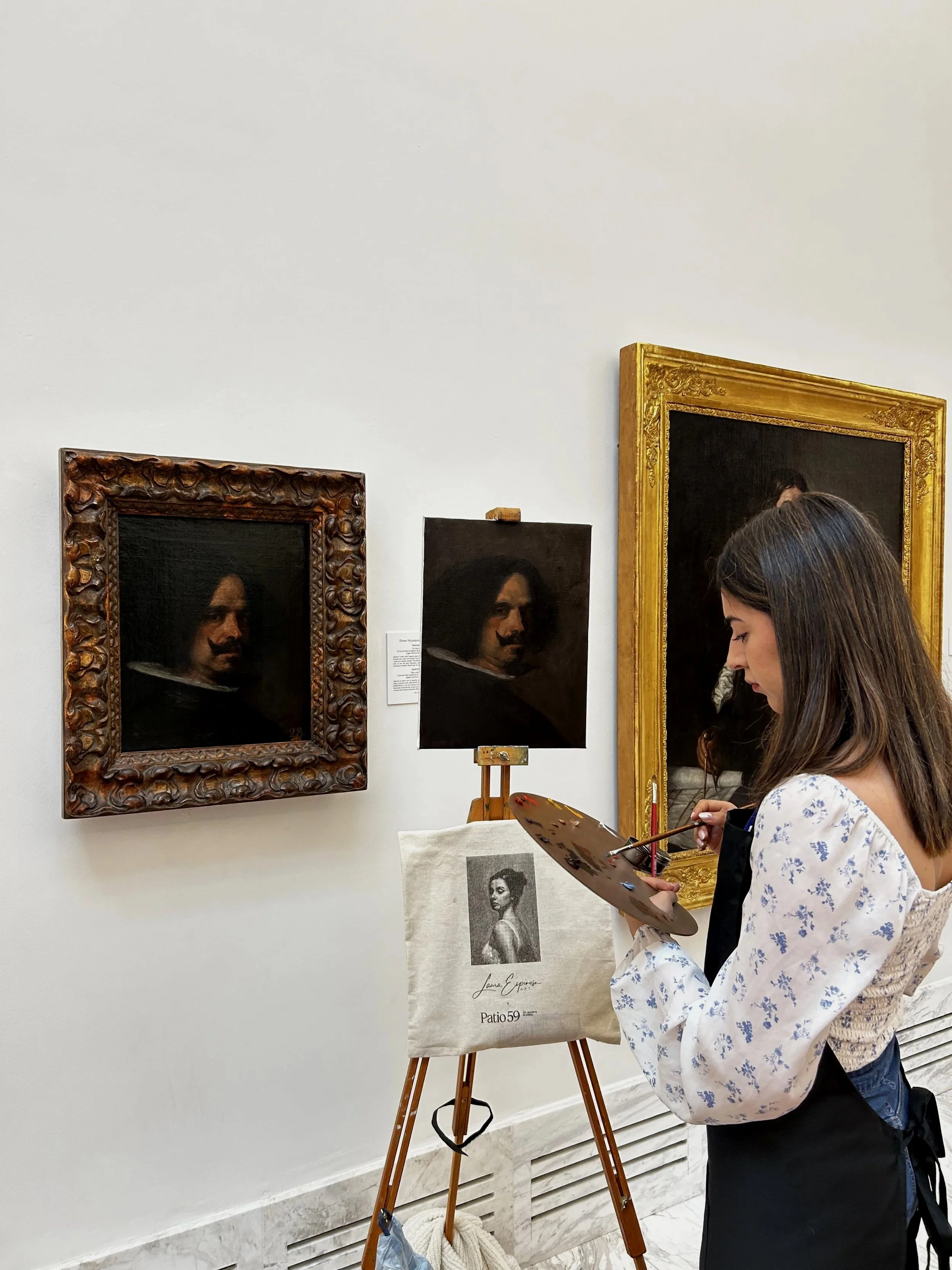 Mujer pintora en un museo, observando y pintando retratos clásicos en el caballete de pintura.