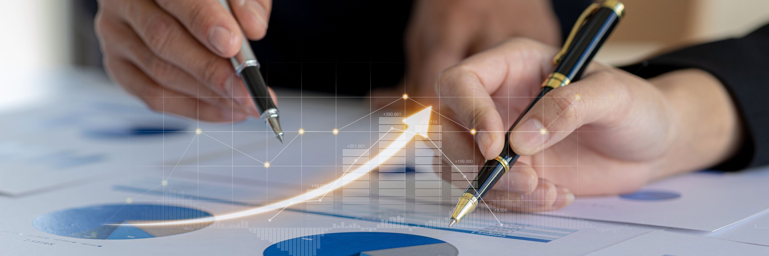 2 hands review finance reports with an arrow growing upwards