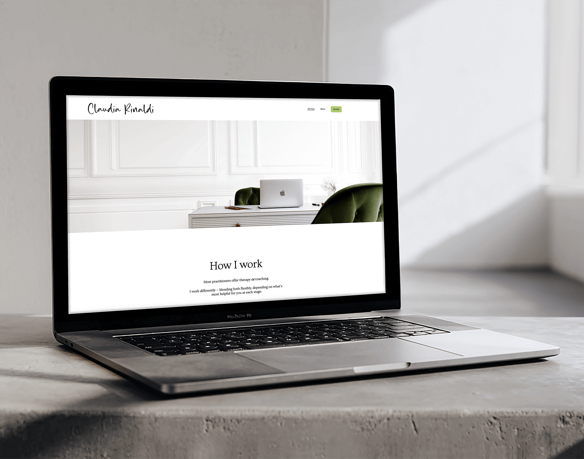 Open MacBook laptop on a concrete table displaying a website titled 'Claudia Rinaldi' with navigation options and a section labeled 'How I work' against a minimalist white wall background.