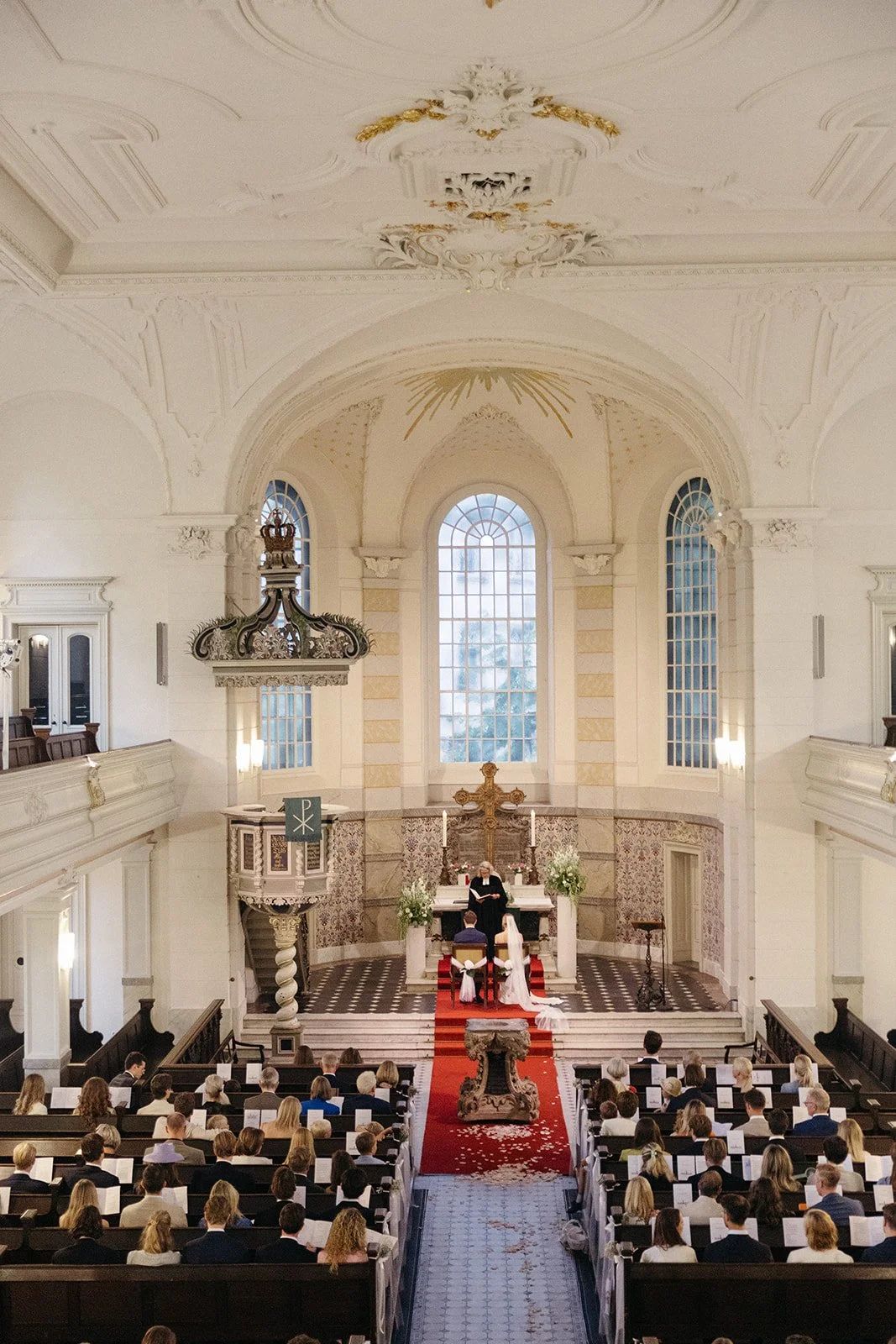 A wide angle shot of a church wedding scene in Sophienkirche in Berlin. 